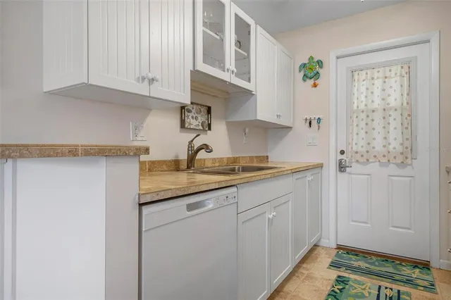 a kitchen with granite countertop white cabinets and sink