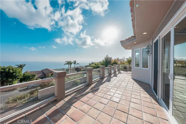 an empty room with wooden floor fireplace and windows