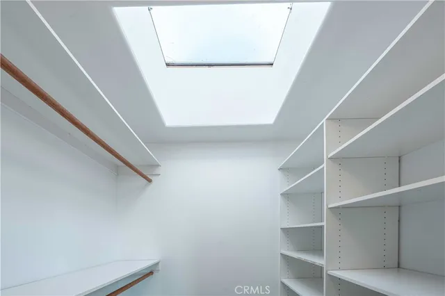 a view of an empty room with wooden floor closet and windows