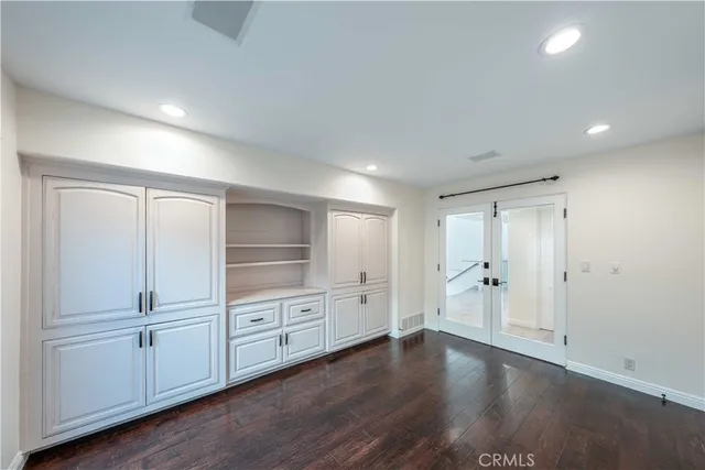 a view of a room with a hanging light and kitchen view