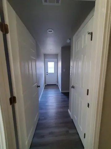 a view of a hallway with wooden floor and staircase