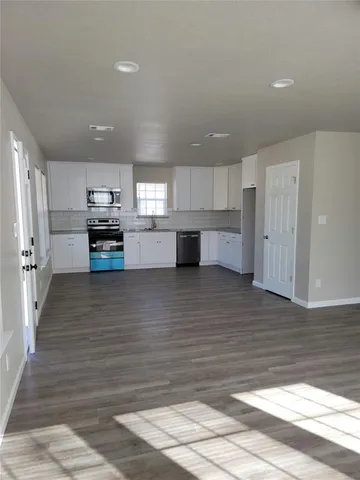 a kitchen with stainless steel appliances wooden floor and refrigerator