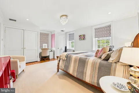 a spacious bedroom with a bed a couch and a window