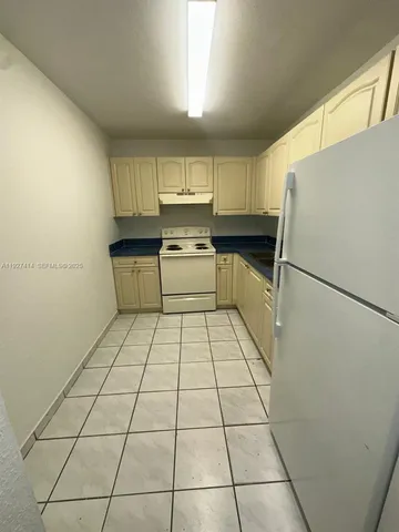 a kitchen with stainless steel appliances a refrigerator sink and cabinets