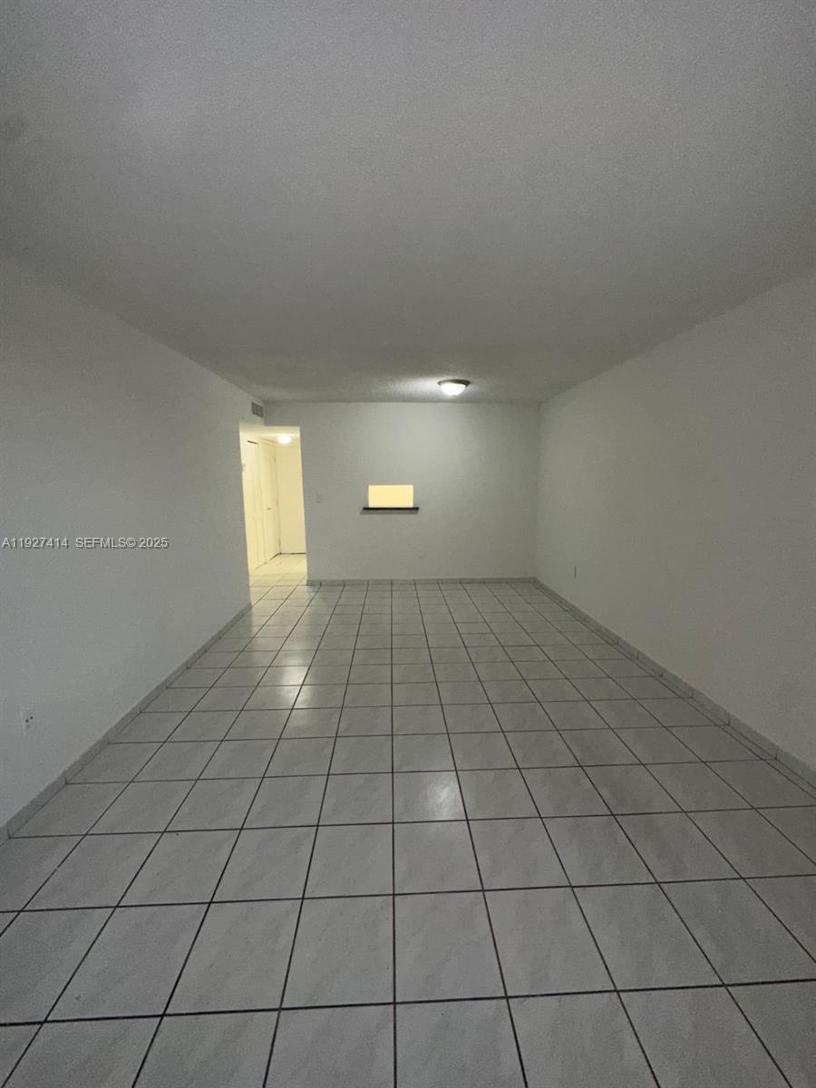 5665 West 20th Avenue, Unit 308 Hialeah, FL 33012 - Photo 6 of 17 a view of an empty room and window