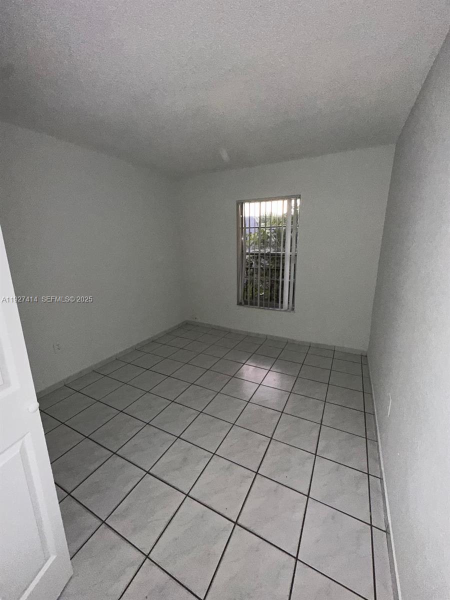 5665 West 20th Avenue, Unit 308 Hialeah, FL 33012 - Photo 9 of 17 a view of an empty room and window