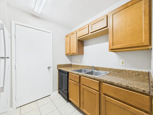 a kitchen with a refrigerator and a stove top oven