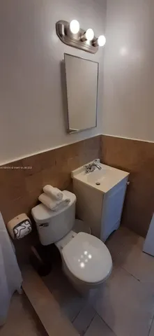 a bathroom with a toilet a sink and mirror
