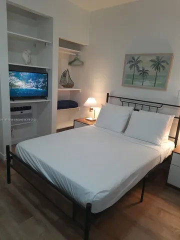 a bedroom with a bed and a flat screen tv