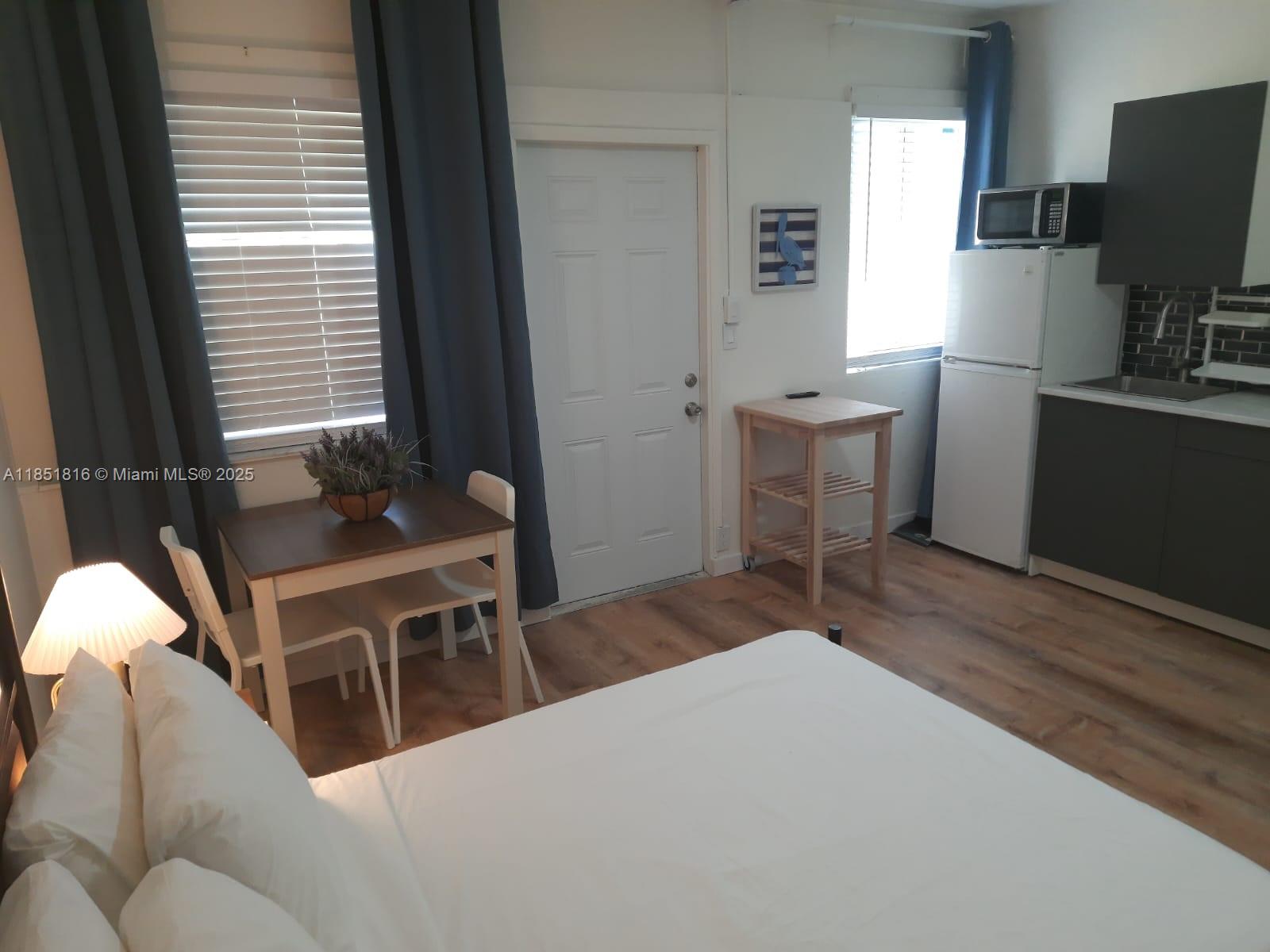 709 Northeast 2nd Court, Unit 2 Hallandale Beach, FL 33009 - Photo 7 of 8 a bedroom with a bed and a desk in it