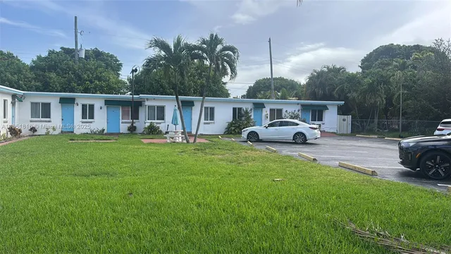 a front view of a house with garden and trees