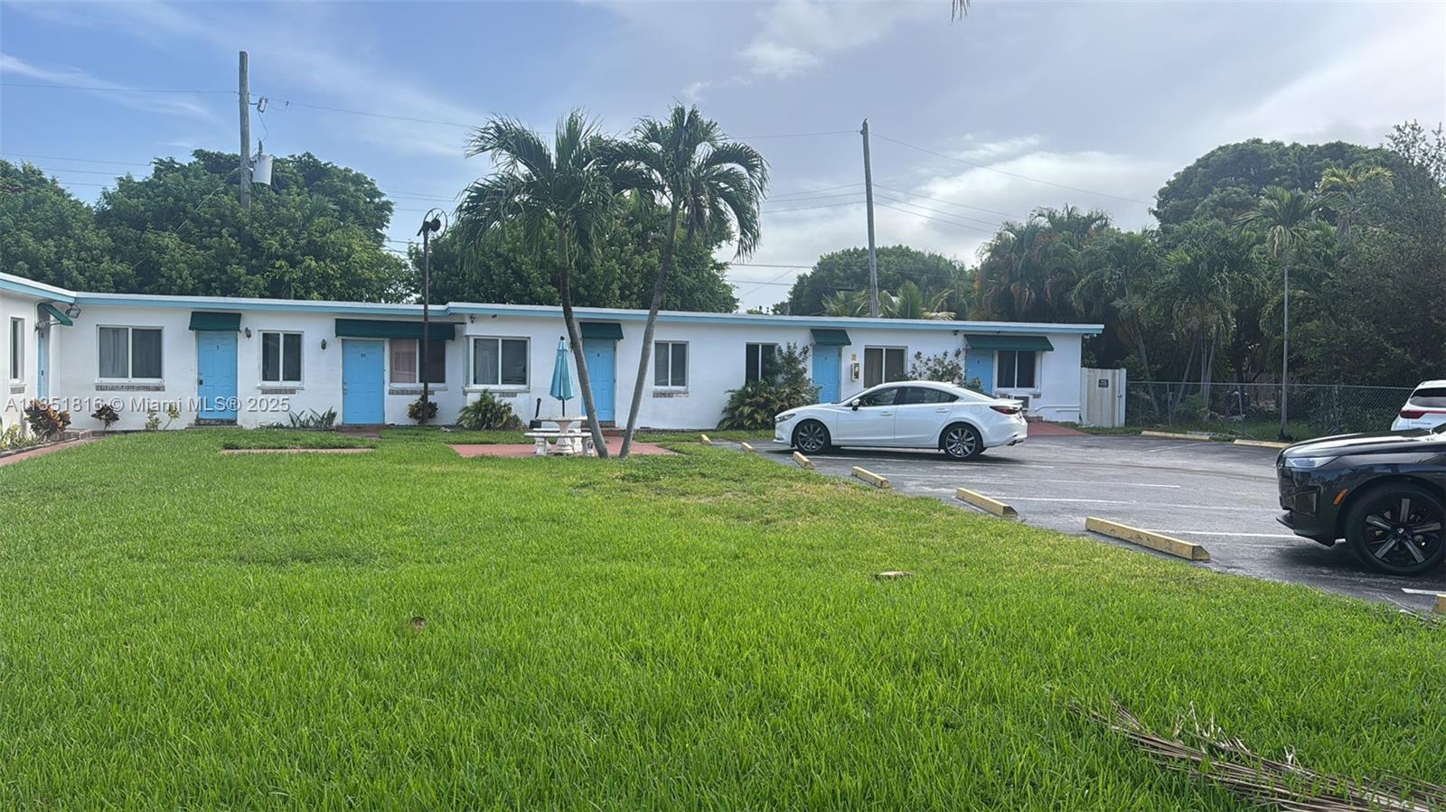 709 Northeast 2nd Court, Unit 2 Hallandale Beach, FL 33009 - Photo 8 of 8 a front view of a house with garden and trees