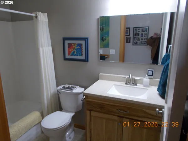a bathroom with a granite countertop toilet sink and mirror