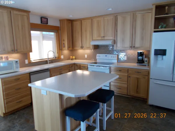 a kitchen with a table chairs refrigerator and cabinets