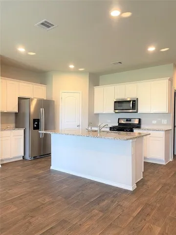 a kitchen with stainless steel appliances a refrigerator sink and microwave