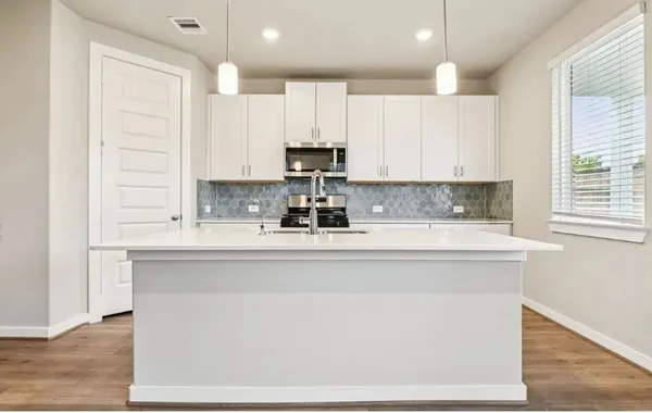 a kitchen with cabinets appliances a sink and a counter top space