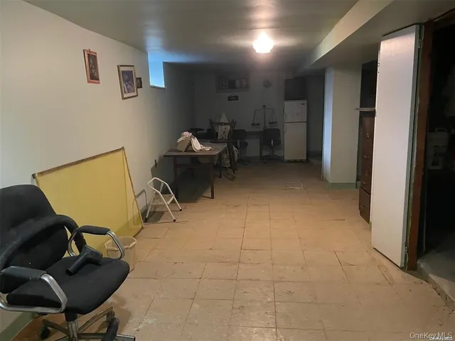 a view of a workspace with furniture and a refrigerator