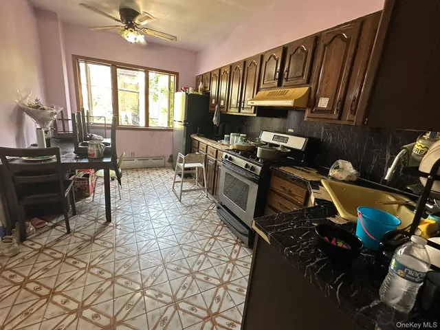 a kitchen with granite countertop a stove a sink and a dining table
