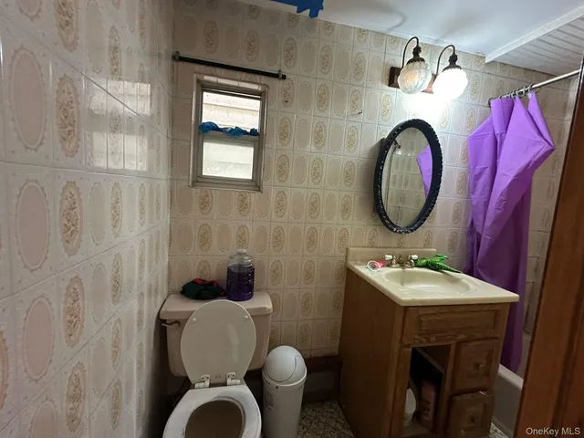 a bathroom with a toilet sink vanity mirror and mirror