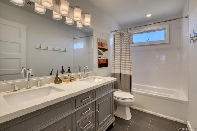 a bathroom with a sink a toilet and a large mirror
