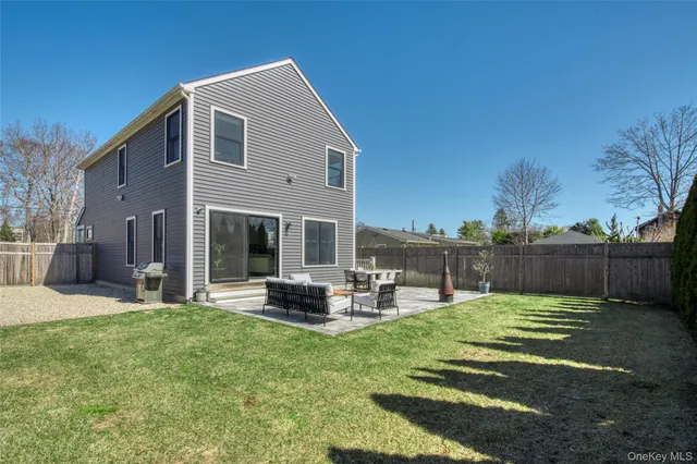 a view of a backyard with table and chairs potted plants and wooden fence