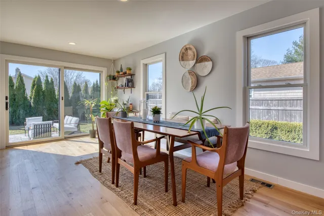 a view of a dining room with furniture wooden floor and garden view