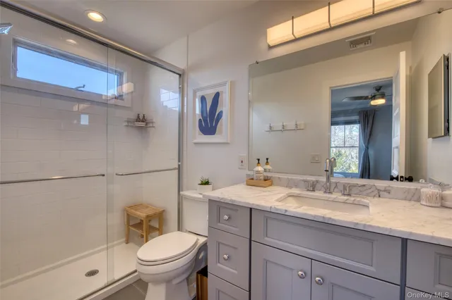 a bathroom with a granite countertop sink toilet and shower