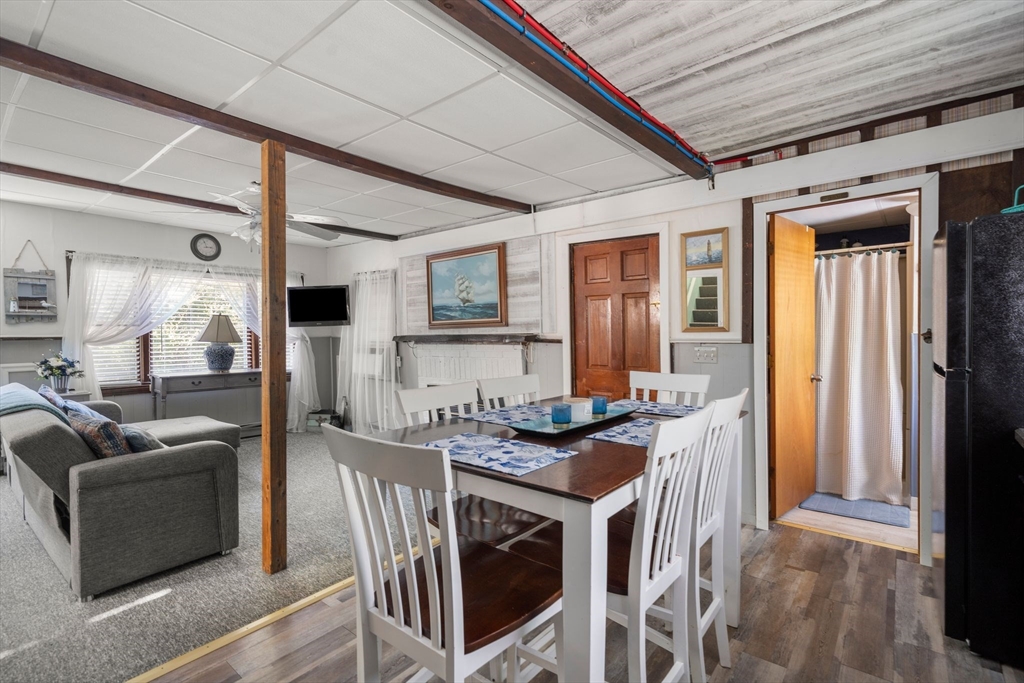 81 Constellation Road Marshfield, MA 02050 - Photo 9 of 42 a open kitchen with stainless steel appliances granite countertop a stove a refrigerator a couch and a dining table with wooden floor