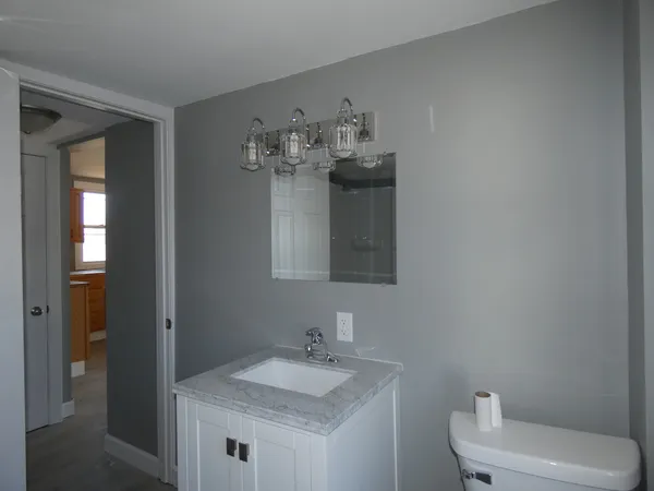 a bathroom with a toilet sink and mirror
