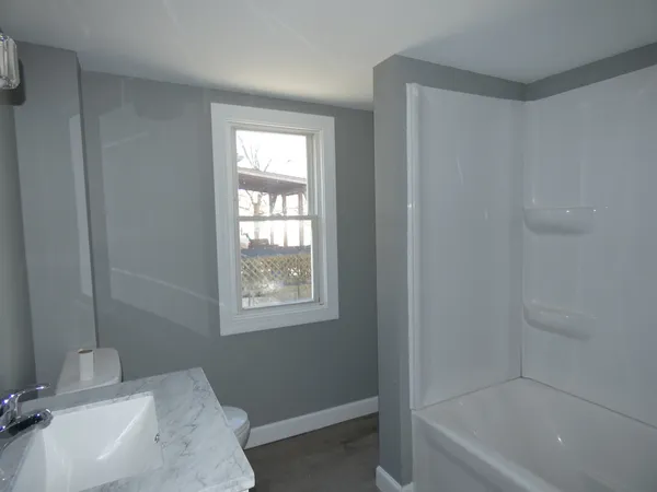 a bathroom with a tub sink and a window