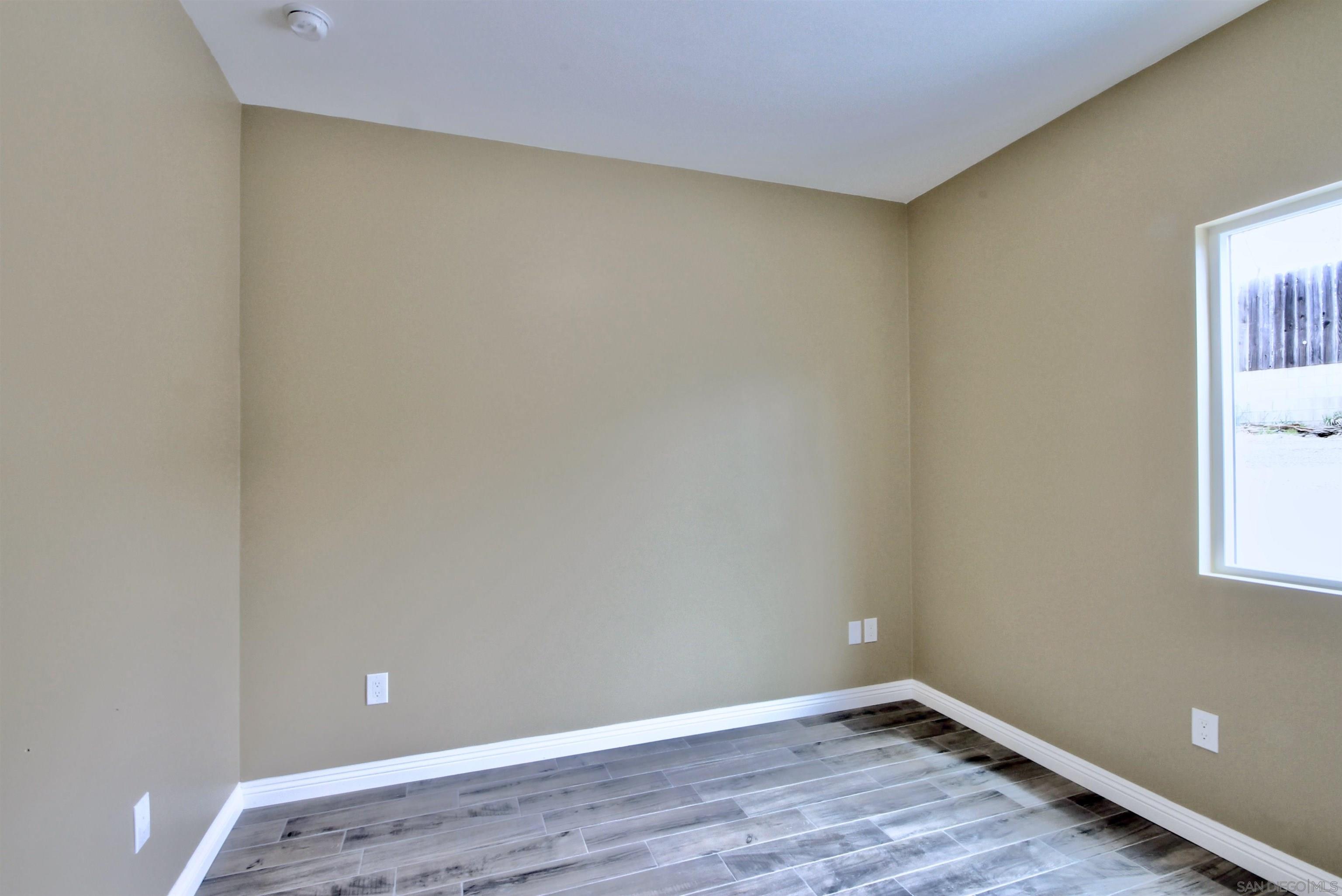 903 Concepcion Avenue Spring Valley, CA 91977 - Photo 34 of 41 a view of an empty room with wooden floor and a window