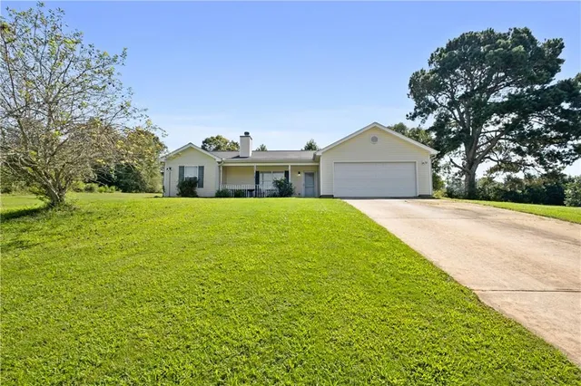 a front view of a house with yard and green space