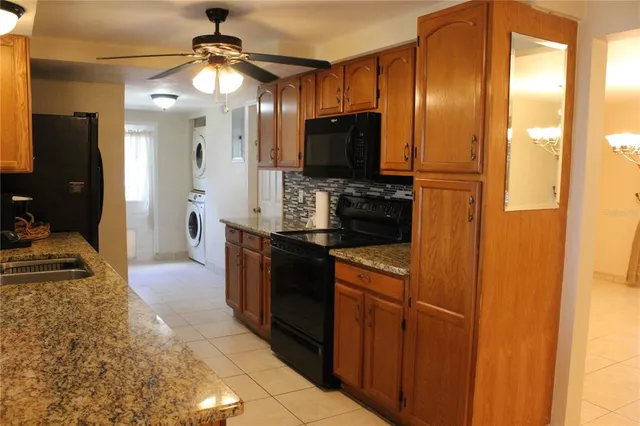 a kitchen with stainless steel appliances granite countertop a refrigerator a stove and a sink
