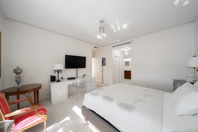 a spacious bedroom with a bed and a flat screen tv