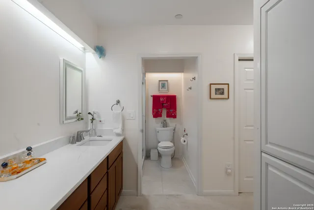a bathroom with a sink vanity mirror and toilet