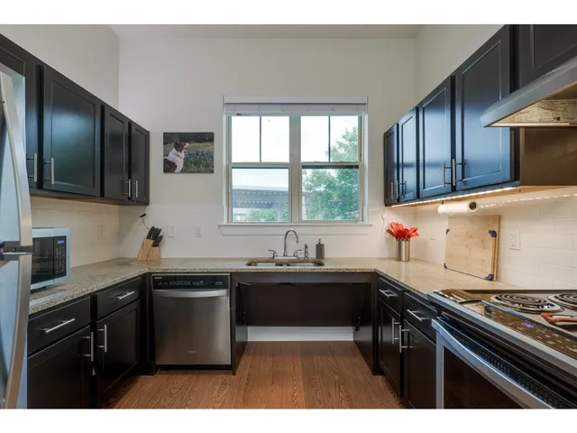 a kitchen with a sink a stove and cabinets