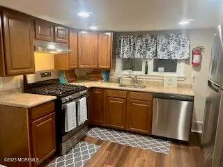 a kitchen with stainless steel appliances granite countertop a stove a sink and a microwave