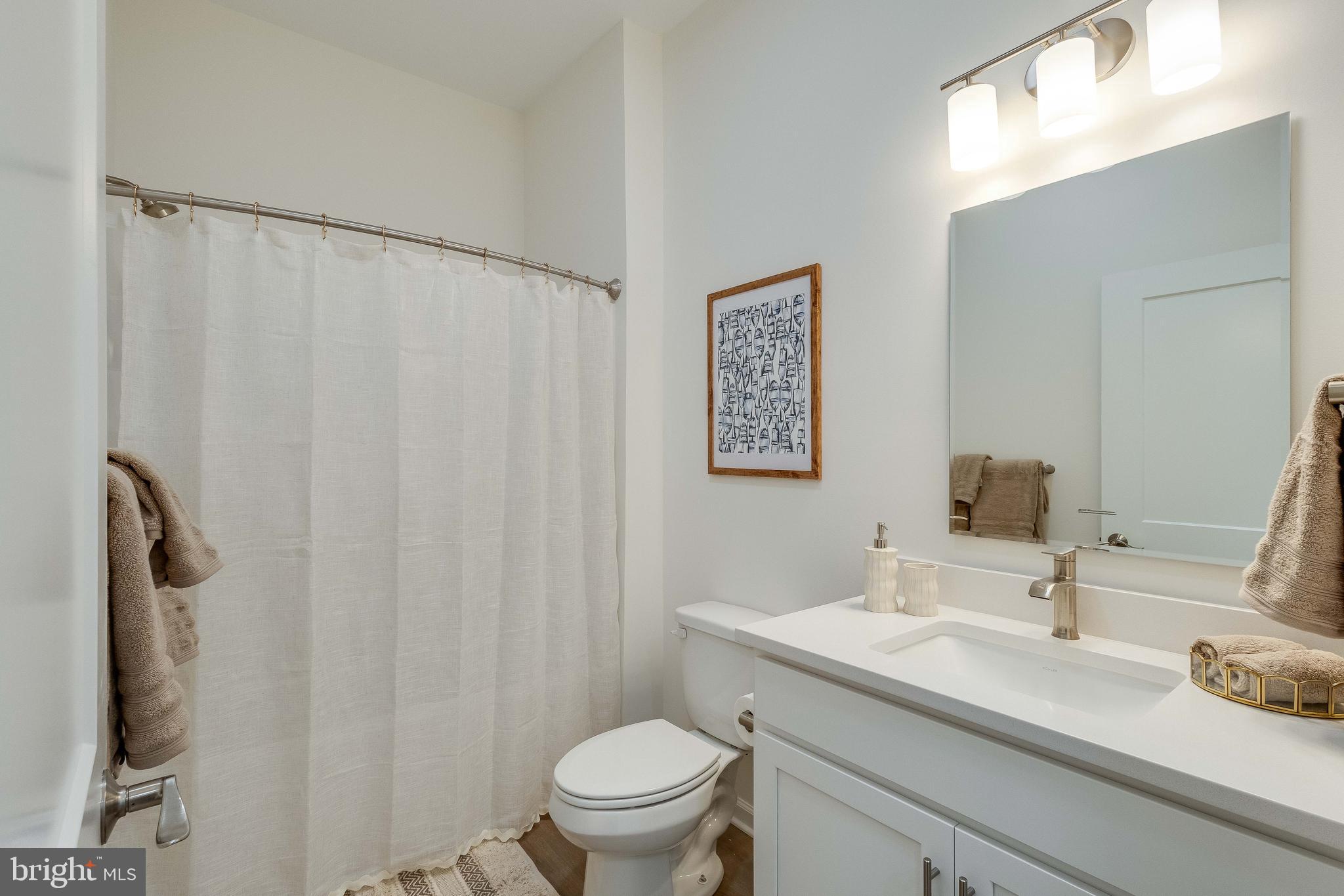 2 Bowers Drive, Unit 103 Ocean View, DE 19970 - Photo 19 of 52 a bathroom with a sink a toilet and shower curtain