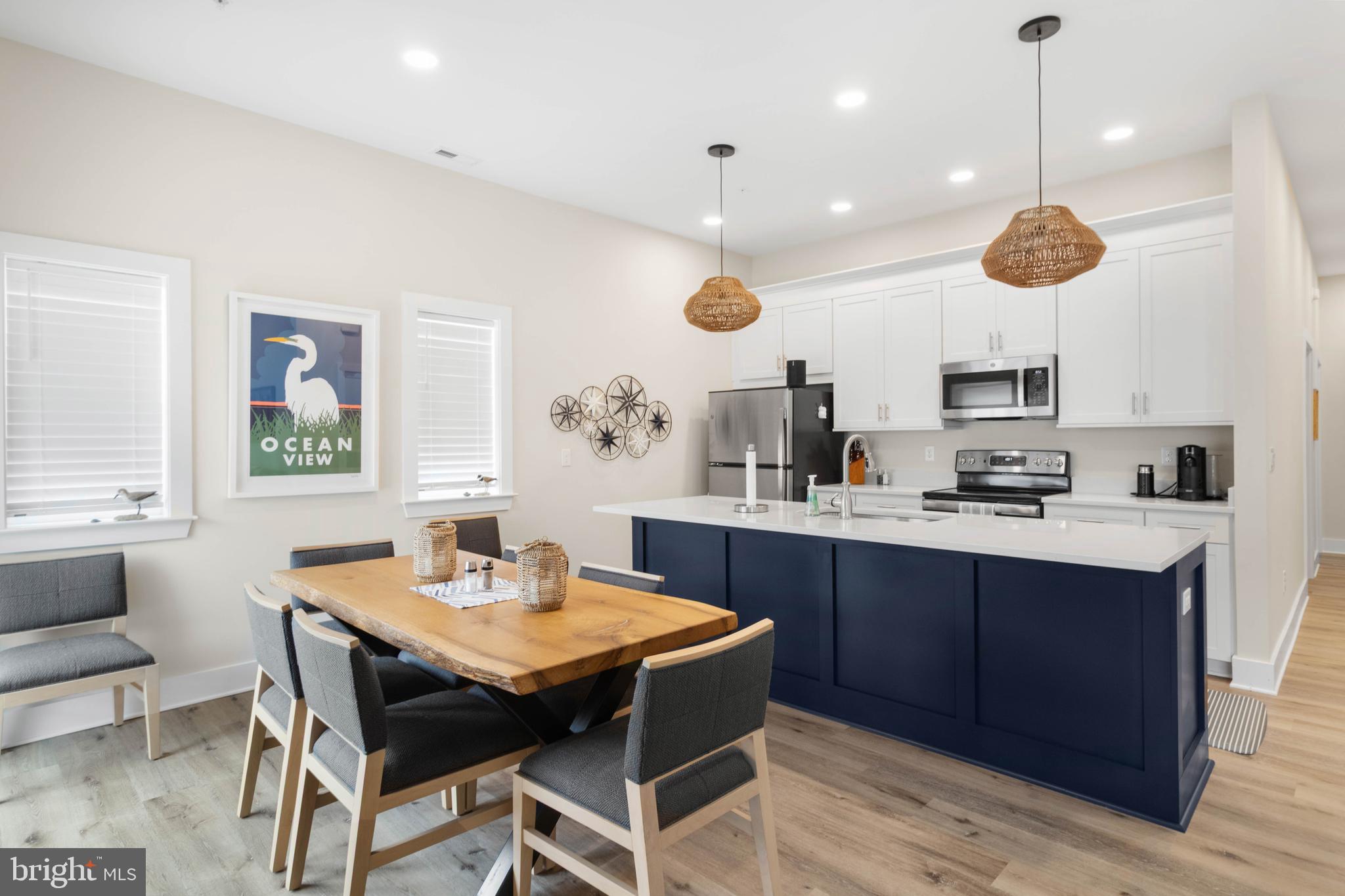 2 Bowers Drive, Unit 103 Ocean View, DE 19970 - Photo 2 of 52 a kitchen with a dining table a sink cabinets and stainless steel appliances