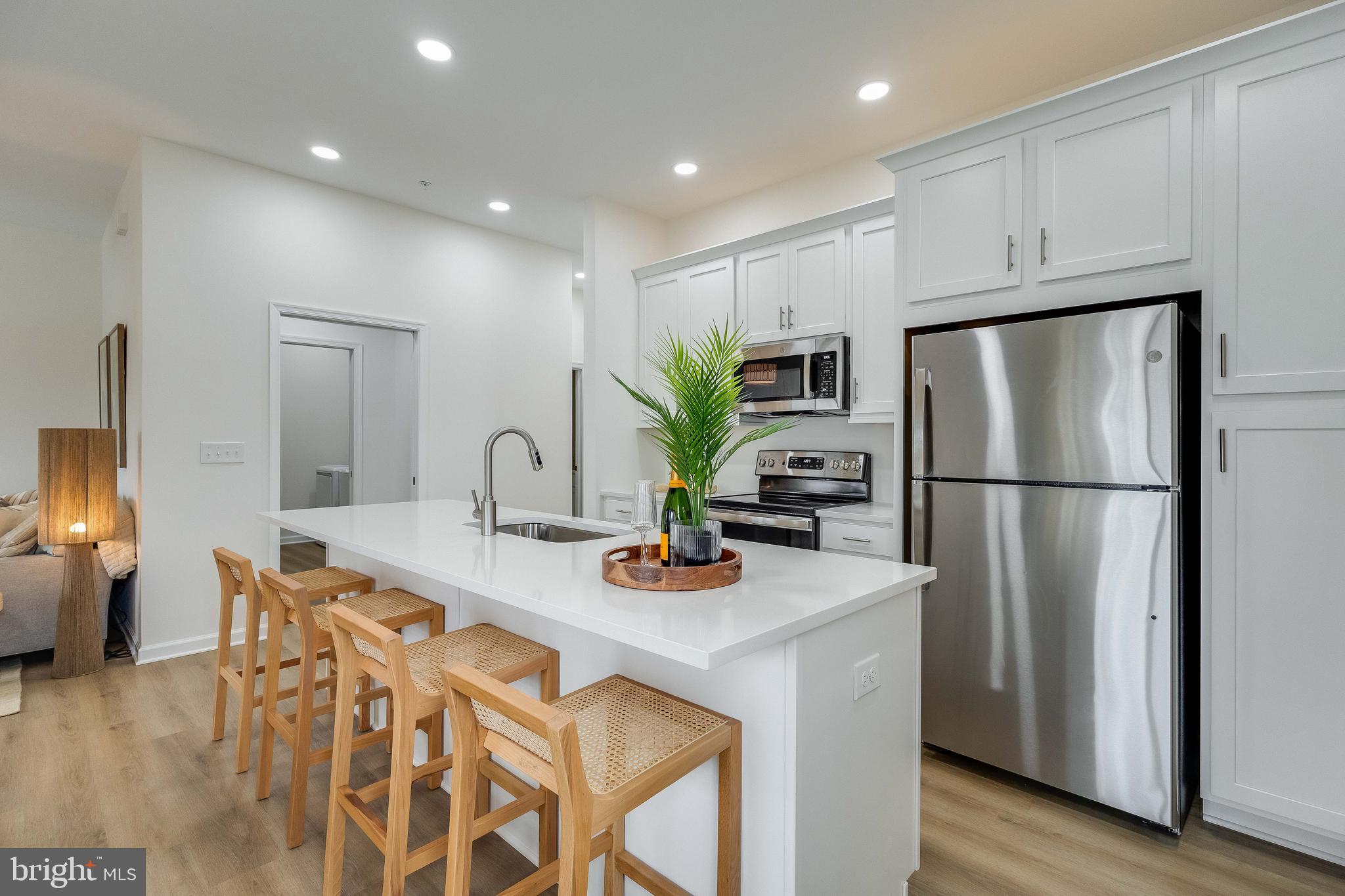 2 Bowers Drive, Unit 103 Ocean View, DE 19970 - Photo 7 of 52 a kitchen with stainless steel appliances a refrigerator a sink a stove a table and chairs
