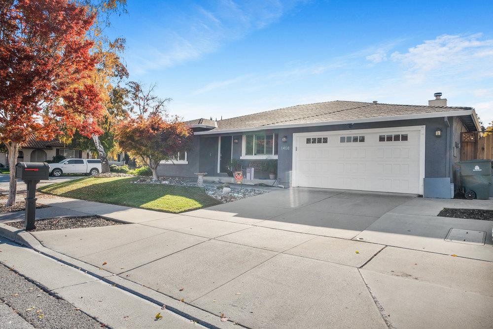 1408 Eagles Nest Lane Gilroy, CA 95020 - Photo 2 of 43 a view of a white house with a yard and table and chairs under an umbrella
