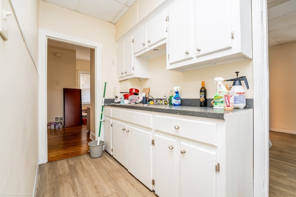 772 Globe Street Fall River, MA 02724 - Photo 9 of 23 a kitchen with white cabinets and wooden floor