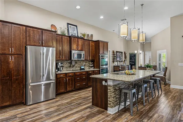 a view of a dining room and livingroom with furniture wooden floor a chandelier