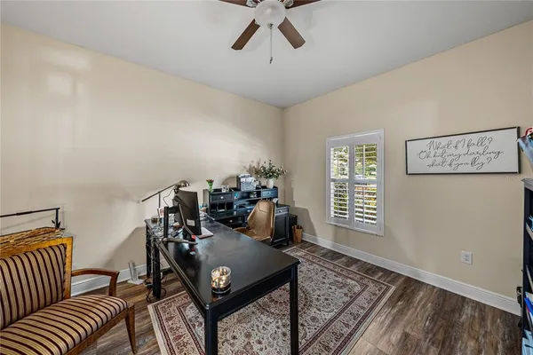 a view of a workspace with furniture and a ceiling fan