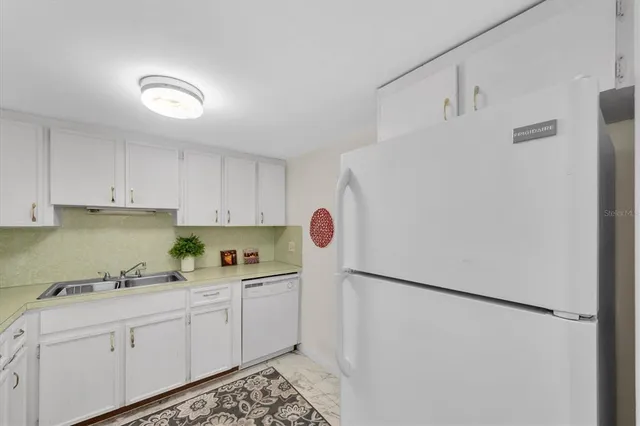 a kitchen with stainless steel appliances white cabinets and a refrigerator