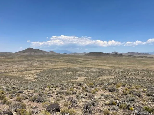 a view of a large mountain with mountains in the background