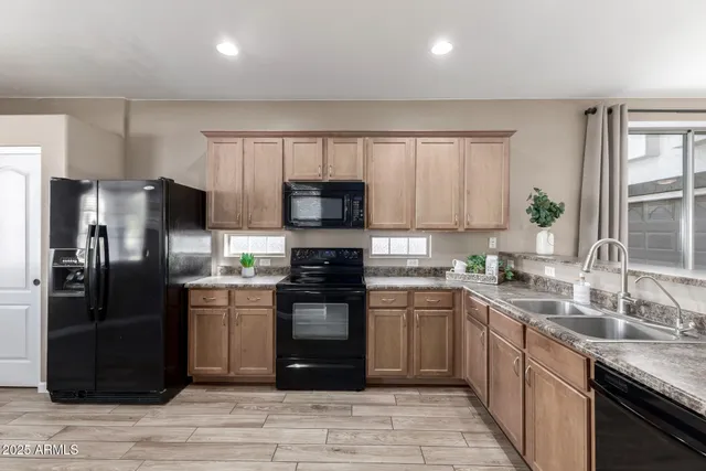 a kitchen with granite countertop a refrigerator stove top oven and sink