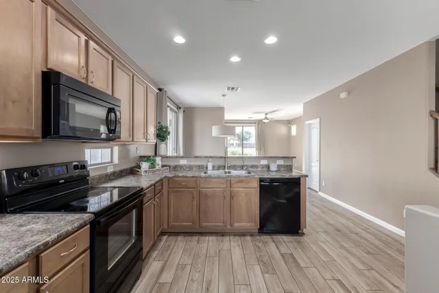 an empty room with wooden floor cabinet and windows