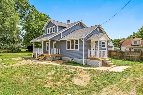 a view of a house with a yard patio and a garden