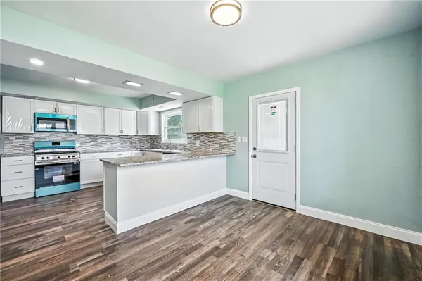 a kitchen with granite countertop a refrigerator and a sink